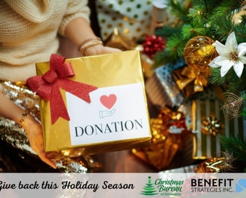 Image of person by a Christmas tree with a box marked "Donation"