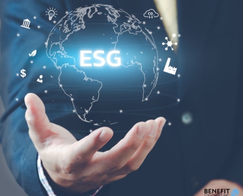 Clear graphic of the world in the palm of a man's hand with the letters ESG over it.